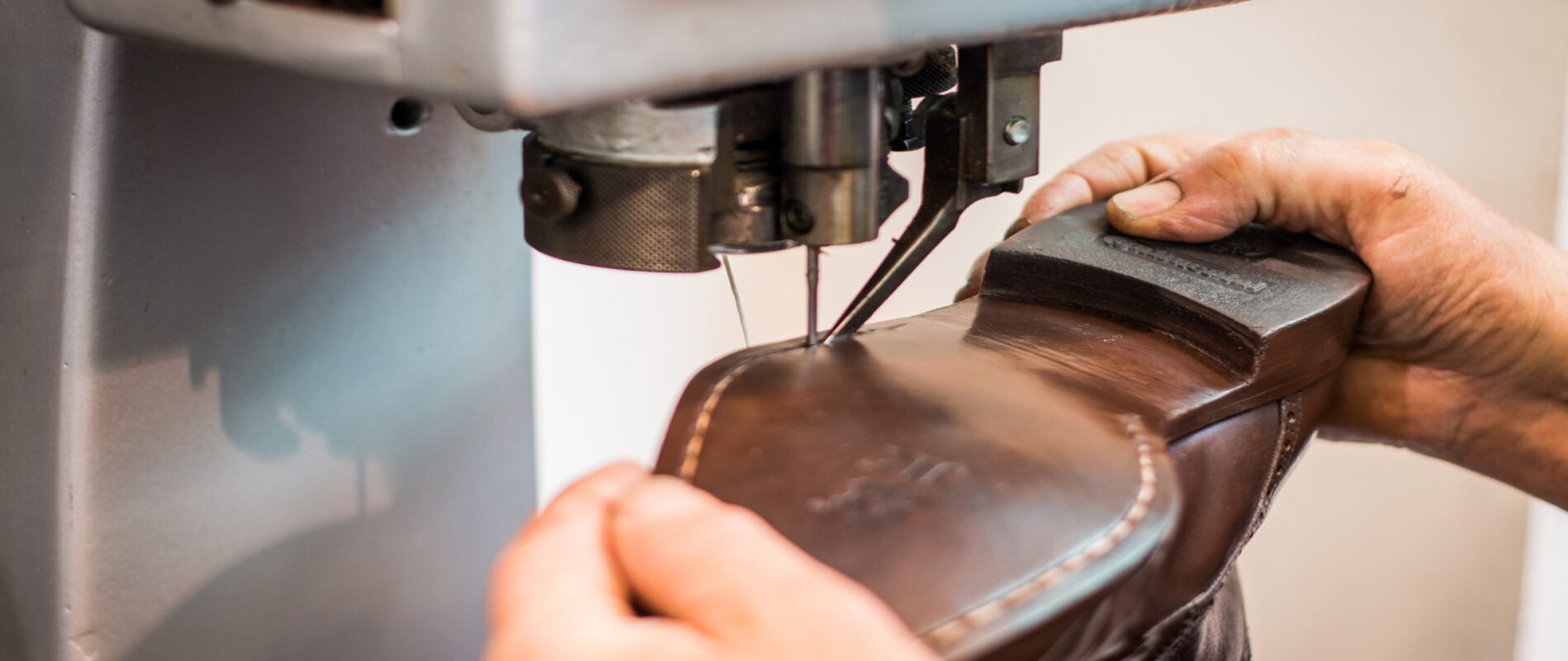 Schoen wordt gestikt op een schoenmakersmachine
